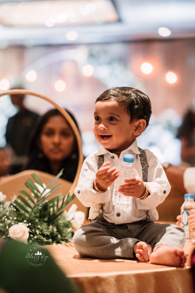 Baby during his baptism reception, surrounded by beautiful venue decorations.