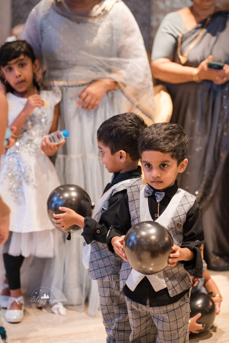 young twin boys holding balloons for a game