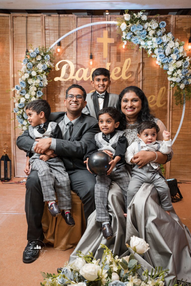 Group photo of a large family with five children, all smiling and dressed in coordinating outfits.