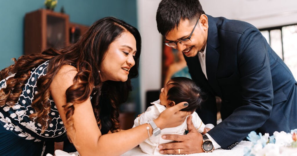 parents getting their newborn child ready at home for the baptism ceremony.