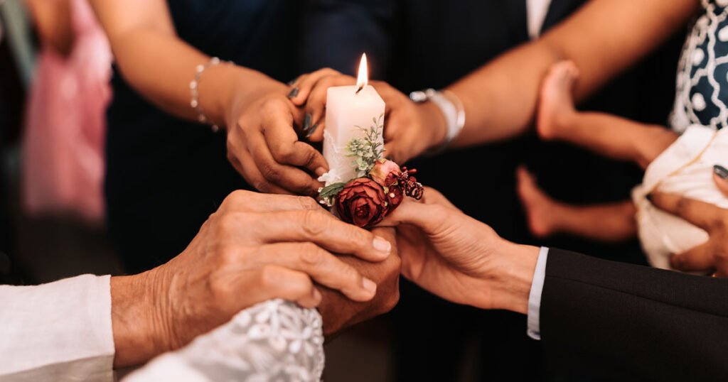 Aesthetic image of people holding a baptism candle, symbolizing unity in faith