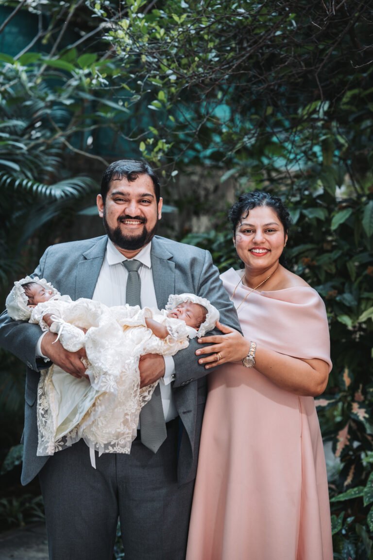 A couple posing with their twin babies