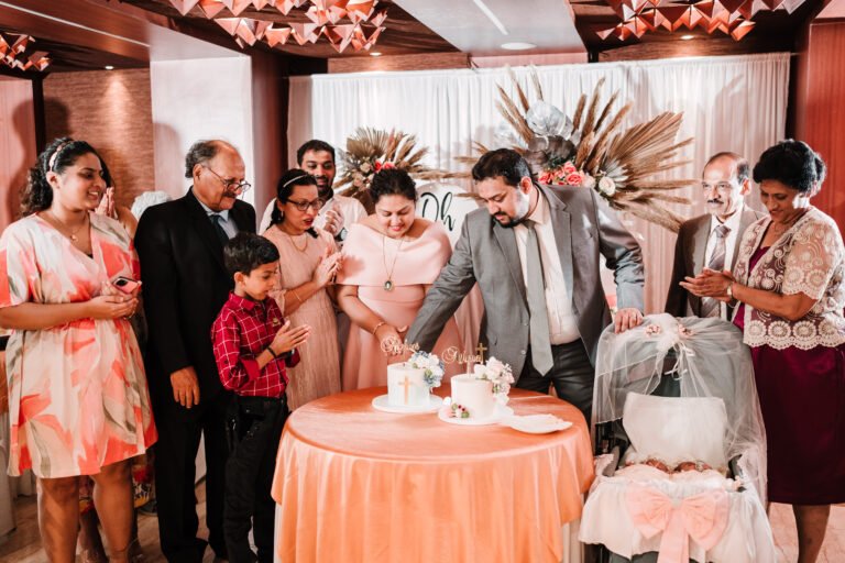 Parents cutting the cake for their babies' baptism