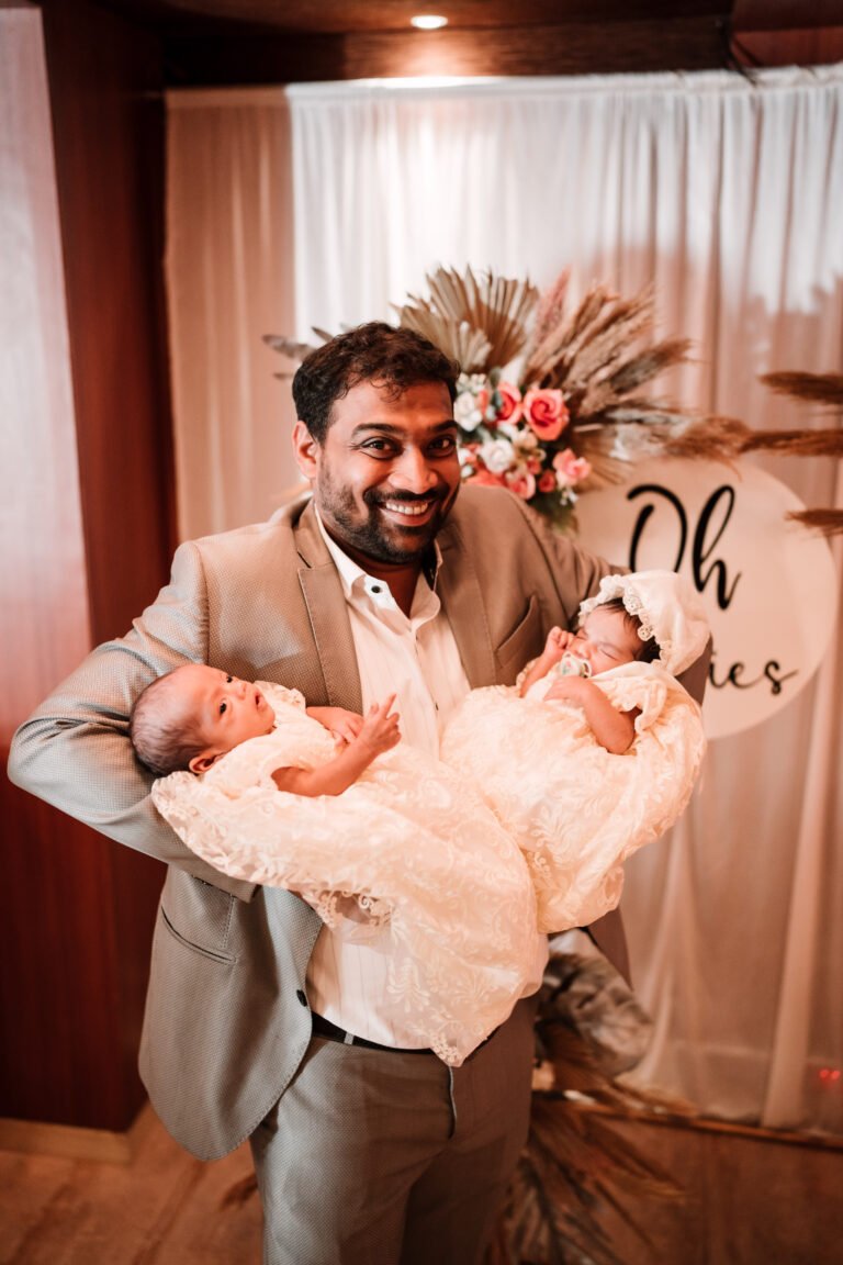 Uncle cheerful holding twin babies at reception