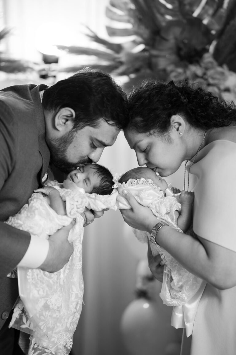 A couple kissing their twin babies, a heartwarming and affectionate posing ideas