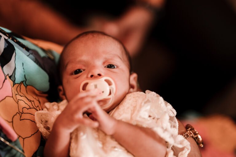 Adorable baby with a pacifier in their mouth, captured during a quiet moment