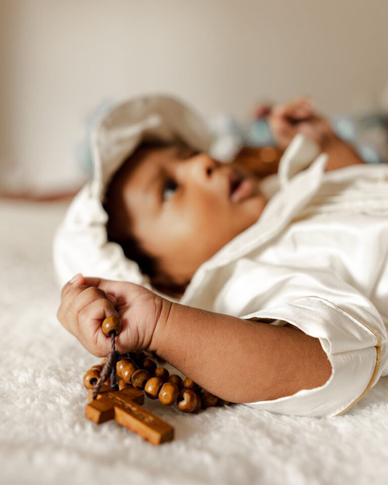 candidate photo of a newborn holding a rosary