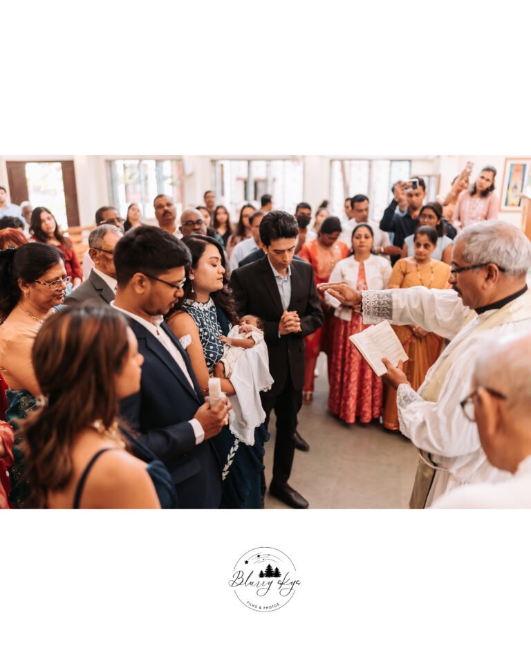 The priest blessing the baby and the whole community praying during a baptism ceremony