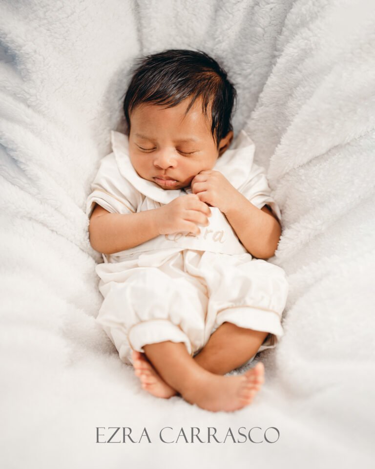 Cute little child peacefully sleeping in a crib during his baptism reception.